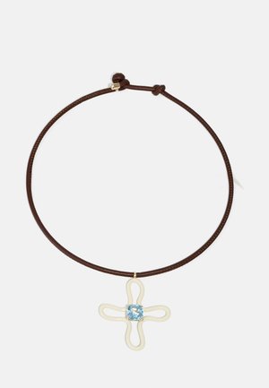 Collier en cuir brun avec un pendentif croix blanc à motifs et un cristal bleu clair au centre.
