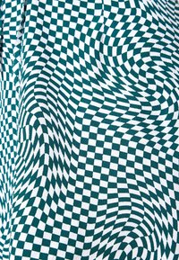 Grüner und weißer Stoff mit einem verzerrten karierten Muster, das eine strukturierte Oberfläche und ein dynamisches, fließendes Design zeigt.