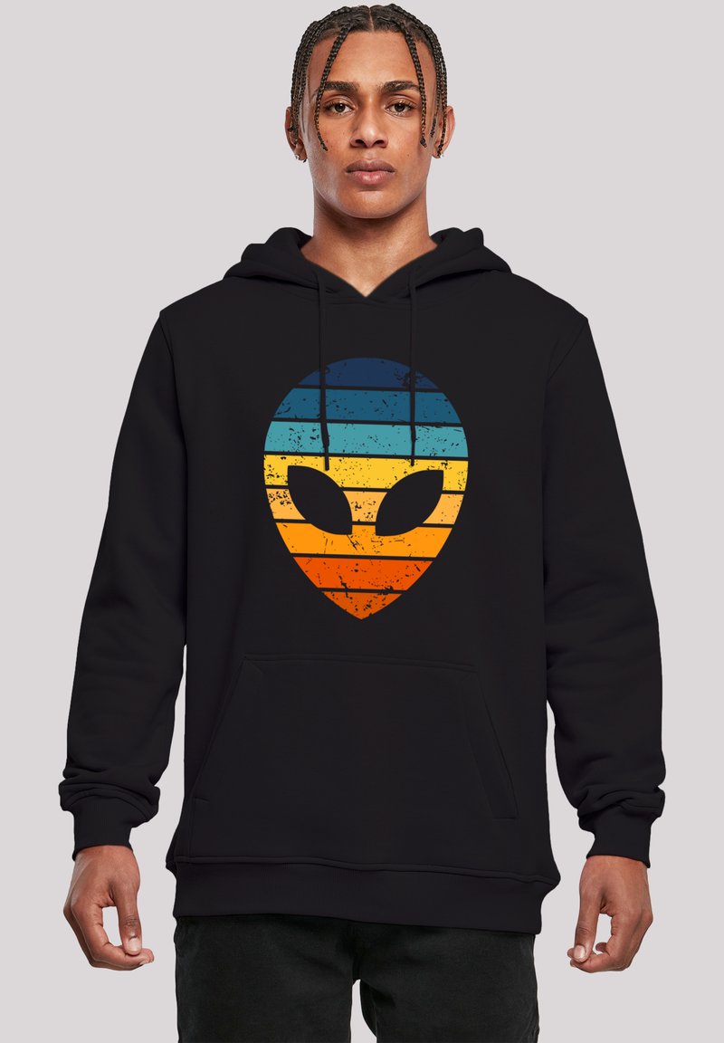 Schwarzer Hoodie mit einem großen Alienkopf-Graphic und horizontalen Streifen in Blau, Türkis, Orange und Gelb. Strukturiertes Finish.