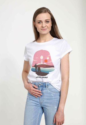 T-shirt en coton blanc présentant un graphique coloré d'un paysage à l'intérieur d'une silhouette de casque, avec le texte "STAR WARS" en bas.