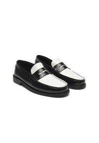 Svarta och vita läderloafers har en slät finish, kontrasterande paneler, en sydd tå och en låg blockklack för enkel användning.