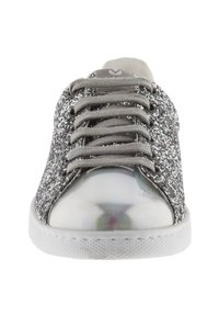 Basket en toile basse avec des côtés en paillettes argentées, un embout métallique argenté, des lacets gris et une semelle en caoutchouc blanche, vue de face.