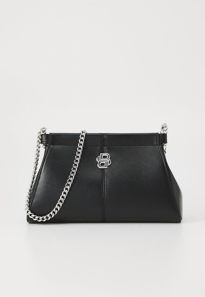 Must musta käekott struktureeritud kujuga, millel on hõbedane kettvõru ja logo aktsent ees. Sile tekstuur ja minimalistlik disain.