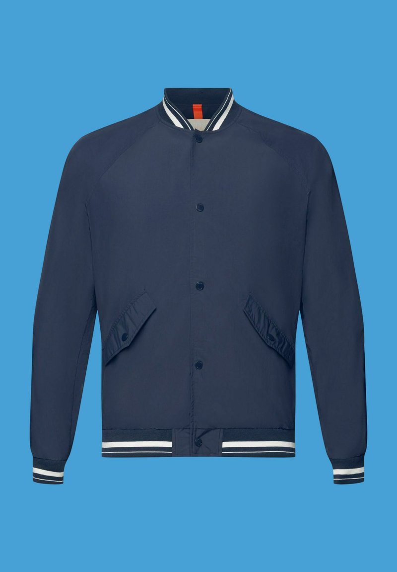 Veste de bombardier navy avec fermeture à boutons-pression, manches raglan, poches latérales à rabat et poignets et ourlet à rayures côtelées. Texture de tissu lisse.