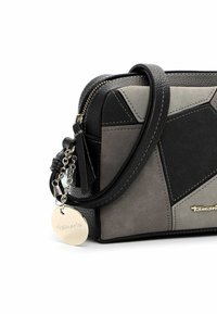 Borsa a tracolla geometrica nera e grigia con pelle sintetica testurizzata, chiusura con zip e etichetta logo argentata. Presenta una tracolla rimovibile.