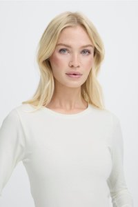 Top blanco de manga larga hecho de una tela suave y ligera, con un cuello redondo clásico y una silueta ajustada.