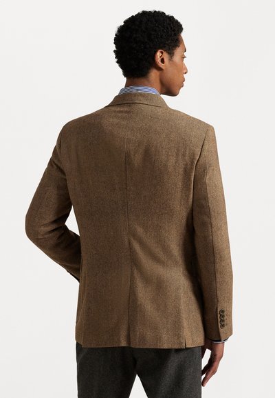 Bruine herringbone blazer met een reverskraag, enkele achteropening, knoopmanchetten en een gestructureerde stof. Gestreept shirt zichtbaar bij de kraag.