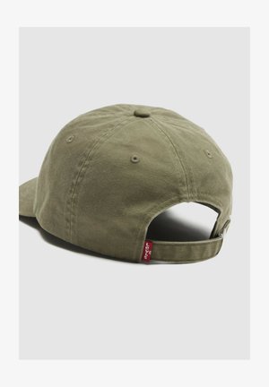 Olive green adjustable baseball cap with fabric strap and metal buckle, featuring a small red Levi’s logo tag at the back.