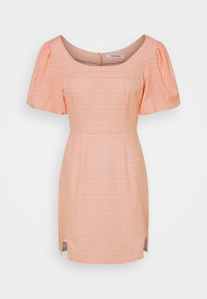 Robe courte couleur pêche avec motif à carreaux blancs, manches courtes bouffantes, encolure carrée, taille cintrée et petites fentes devant la jupe.