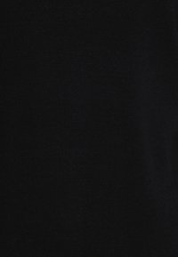 Svart stickad tyg, fin textur med en slät yta. Enhetlig färg genom hela tyget utan synliga mönster eller accenter.