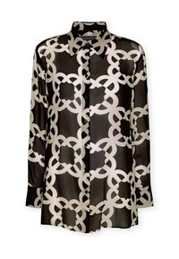 Blusa nera trasparente con un motivo geometrico a catena bianca, maniche lunghe, colletto e chiusura con bottoni. Tessuto morbido e leggero.