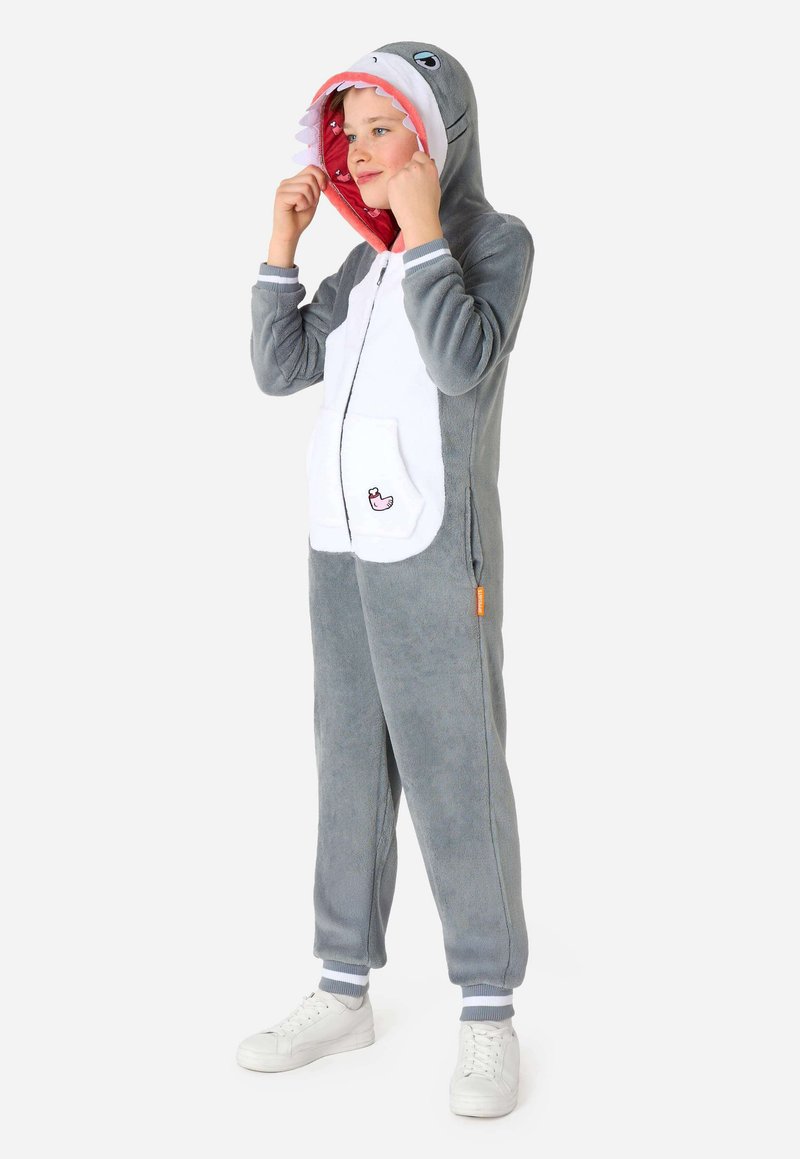 Grijze vinvis-thema onesie met een rood omrandde capuchon, een witte buik, zakken en grijze manchetten. Zachte, gestructureerde stof geschikt voor loungewear.