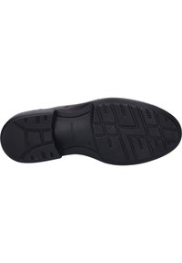 Schwarze Gummisohle mit strukturiertem Grip-Muster, das rechteckige und Zickzack-Designs für Traktion und Stabilität aufweist.