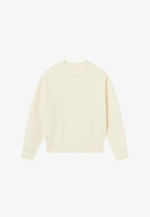 Suéter de punto color crema con patrón texturizado, cuello redondo y puños acanalados. Presenta un leve hombro caído y un pequeño logo en el dobladillo.