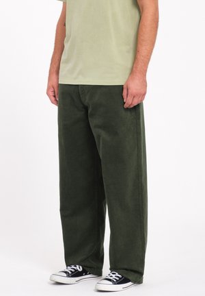 Green corduroy wide-leg pants with a soft texture. Worn with a light green shirt and black and white sneakers. Simple, practical design.