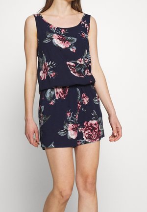 Blomstret romper i marineblå stof med pink og hvide blomster. Uden ærmer med en afslappet talje og kort længde.