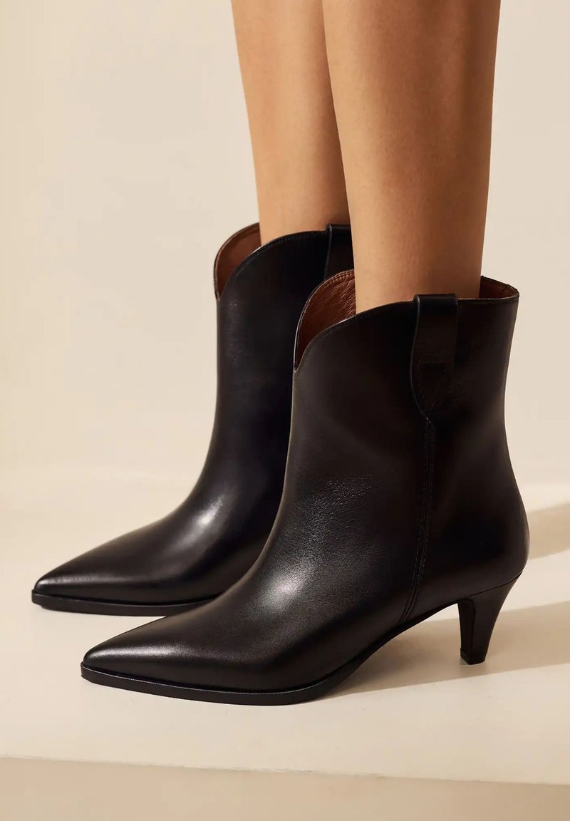 Schwarze Lederstiefeletten mit spitzer Zehenform und 5 cm Absatz. Sie verfügen über eine glatte Oberfläche, eine schlanke Silhouette und einen geschwungenen Kragen.