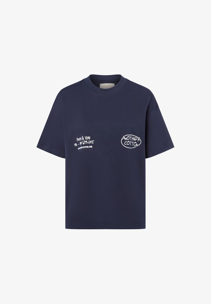 Tums zila kokvilnas T-kreklis ar īsām piedurknēm, kas rotāta ar baltu drukātu tekstu priekšā, kreisajā krūtīs un sānos, ar noapaļotu kakla izgriezumu.