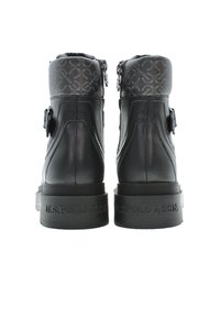 Botines de cuero negro con una parte superior texturizada en gris, acento de hebilla y detalle del logotipo en el talón. Presentan una suela de goma resistente.