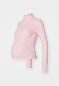 Top premaman di colore rosa chiaro, con colletto alto, maniche lunghe, tessuto elasticizzato e design aderente che mette in risalto la pancia.