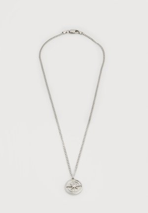 Collar de cadena de plata con un colgante circular de brújula que muestra un diseño de estrella en el centro sobre un fondo blanco.