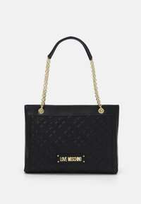 Černá taška na rameno s prošívanou texturou, zlatými řetězy a obdélníkovou logovou deskou. Má robustní ucha a elegantní design.