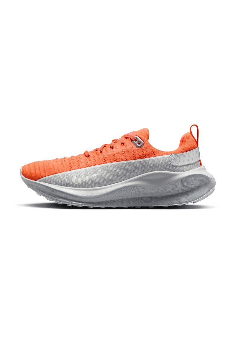 Scarpa da corsa arancione con tomaia testurizzata, suola intermedia bianca e suola esterna nera. Presenta un design con lacci e un'etichetta sul tallone.