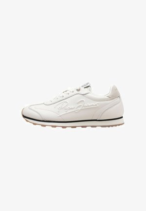 Zapatilla de cuero blanca con textura suave, presenta una línea de acento negra, diseño con cordones y logo en relieve en el lateral. Suela de goma.