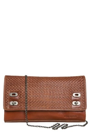 Bruine leren clutch met geweven textuur, zilverkleurige draaisluitingen en een dunne kettingriem op een witte achtergrond.