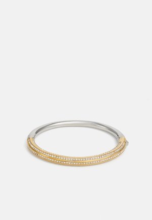 Bracciale rigido in argento e oro con tre file di piccole pietre cristalline trasparenti su un fondo bianco.