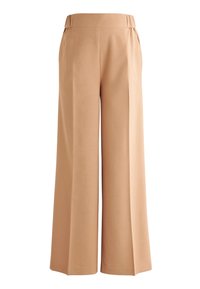Pantalons larges beiges avec une texture lisse, une taille élastique et sans poches visibles. Le design présente une coupe ample sur toute la jambe.