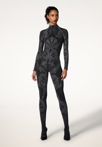 Tuta nera scintillante con collo alto, maniche lunghe e intricati motivi floreali grigi. Il design aderente esalta la silhouette.