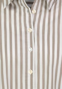 Striped button-up shirt in beige and white. Features a classic collar and three buttons, with a smooth, lightweight fabric.