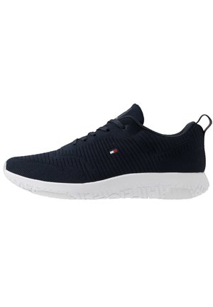 Scarpe sportive in rete blu navy con tomaia testurizzata, suola in gomma bianca e piccolo dettaglio logo sul lato. Design leggero e con lacci.
