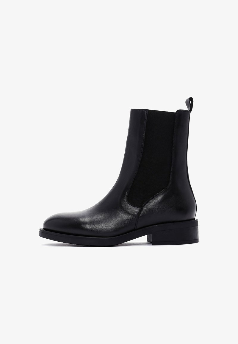 Botas de tobillo de cuero negro con paneles laterales elásticos, punta redondeada, tacón cuadrado corto y un bucle para facilitar su colocación.