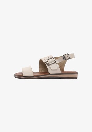 Beige leather sandals with two wide straps, a buckled ankle strap, and a flat wooden sole. Textured insole and smooth outer finish.