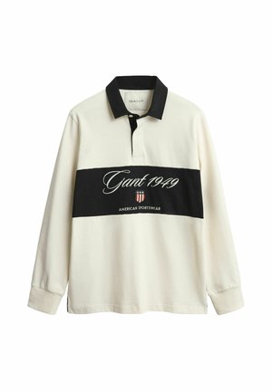 Long-sleeve polo shirt in cream and black, featuring a striped design, embroidered logo, and a classic collar. Made of cotton fabric.