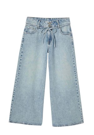 Jean large bleu clair en denim, présentant une fermeture à bouton et un cordon de serrage noué à la taille. Texture lisse avec un léger dégradé.