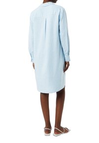 Helles, blau gestreiftes Hemdkleid mit langen Ärmeln, Knopfmanschetten, rückseitigem Falten-Detail und geradem Schnitt, der bis zur Mitte des Oberschenkels reicht.
