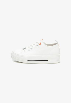 Zapatillas de lona blancas con punta redondeada, suela plana, ojales plateados y acentos naranjas en la parte superior. Presenta una suela de goma texturizada.