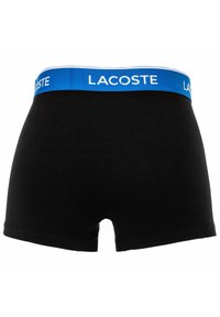 Boxer da uomo neri con una fascia blu che presenta il logo bianco Lacoste.