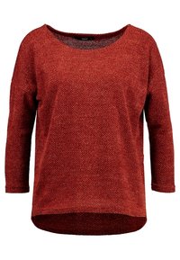 Pull de couleur rouille, texture tricotée, coupe ample, encolure ronde, manches trois-quarts, ourlet arrière plus long, sans éléments métalliques apparents.