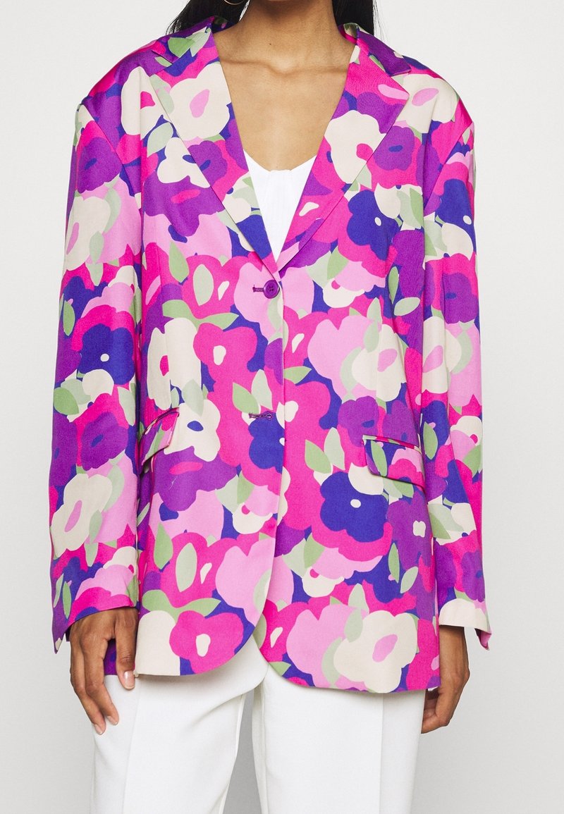 Blazer à motif floral dans des tons de rose, violet et vert. Présente un revers cranté, une fermeture à un bouton et deux poches avant. Texture soyeuse.