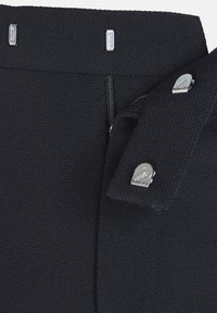 Black textile waistband with smooth texture, featuring two silver hardware fasteners. Vertical alignment and zipper detail on the left side.