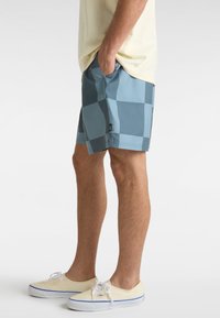Badeshorts im blauen und türkis karierten Muster, aus leichtem Material gefertigt. Verfügt über Seitentaschen und ein Etikett am Saum.