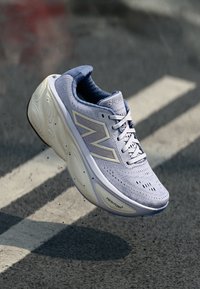 Lys lilla joggesko med en pustende mesh-overdel, har en tykk hvit såle, fremtredende "N"-logo og flere ventilasjonshull.