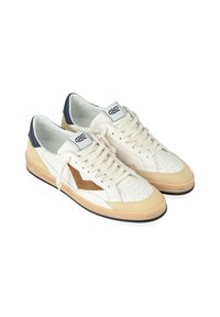 Sneaker bianchi con accenti in suede beige e marrone, punta perforata, lacci bianchi piatti e suola in gomma nera. Presenta un contrafforte del tallone blu navy.