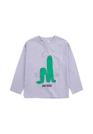 Camisa de manga larga lavanda con una criatura peluda verde sonriente y texto negro "BOBO CHOSES" en la parte delantera, con dibujos simples de árbol y luna.