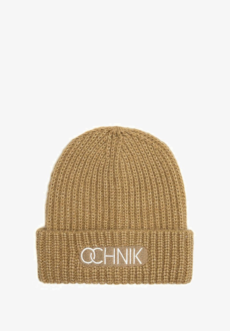 Dzianinowa czapka w jasnobrązowym kolorze z ryflowaną fakturą. Posiada podwinięty mankiet z logo marki wyszytym na biało.