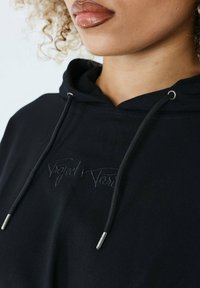 Sort hættetrøje med broderet logo, snoretræk med sølvdetaljer, blød tekstur og en afslappet design.